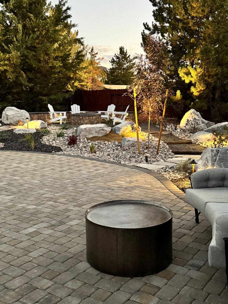 Multi-level backyard with fire feature, integrated lighting, and stone terraces as part of a professional hardscape reno project